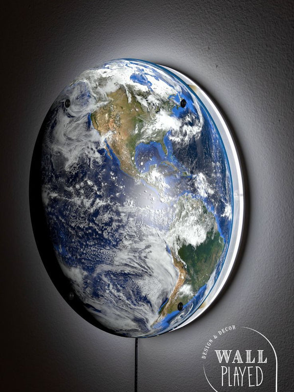 Side view of the Planet Earth wall light glowing on a dark wall