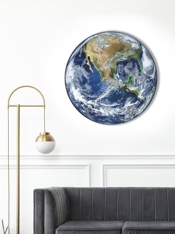 Earth wall light on a white wall above a grey sofa and gold floor lamp