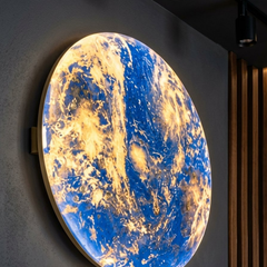 Planet Earth wall light glowing in warm gold tones in a dark room